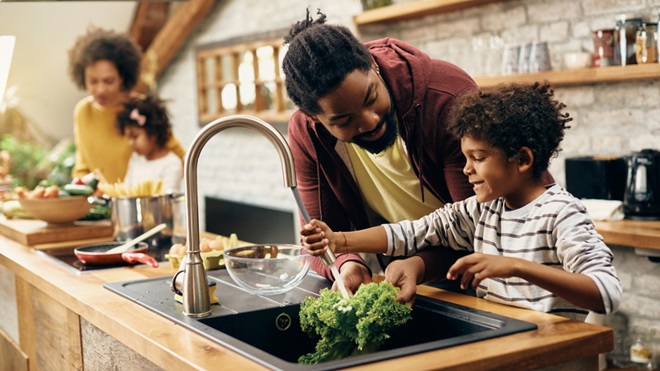 vader en kind wassen groenten in de keuken