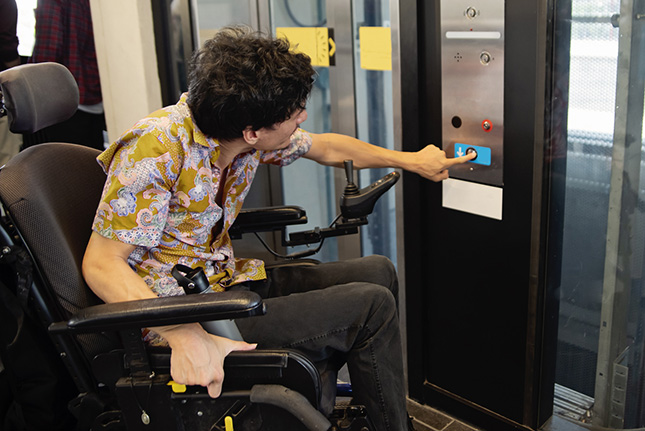 een rolstoelgebruiker bij de lift