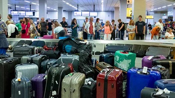 mensen staan te wachten bij de bagageband op het vliegveld met veel bagage om hen heen