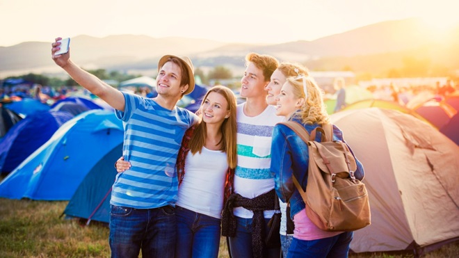 vijf vrienden op festival maken een selfie op de camping