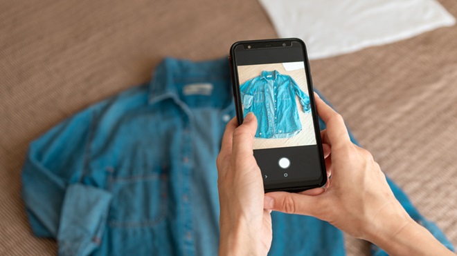 iemand maakt foto van shirt op smartphone om te verkopen op vinted