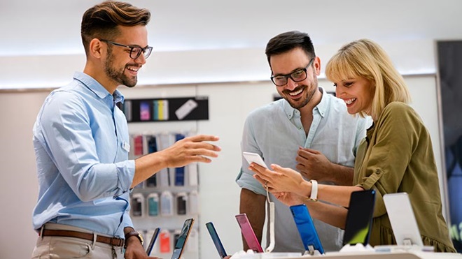 Man en vrouw in de zetel met een feesthoedje, taart en een smartphone