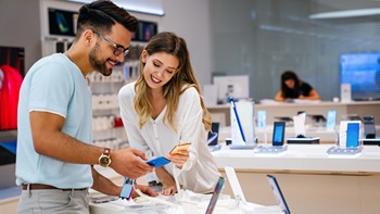 Een vrouw kiest een smartphone in de winkel