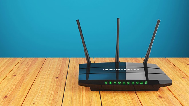 Een router geplaatst op een houten tafel voor een blauw geschilderde muur.