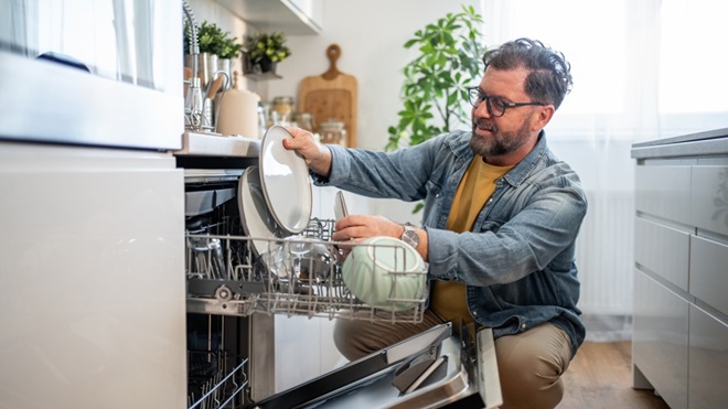 man doet de afwas in de vaatwasser
