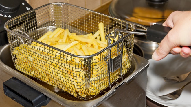 iemand bakt frieten in een friteuse