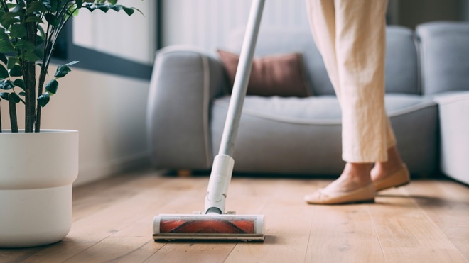 De vloer stofzuigen met een steelstofzuiger