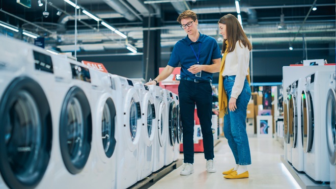 Een verkoper toont wasmachines aan een klant