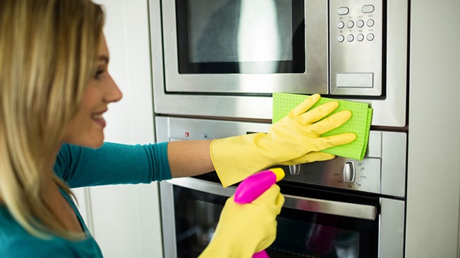 vrouw is oven aan het schoonmaken