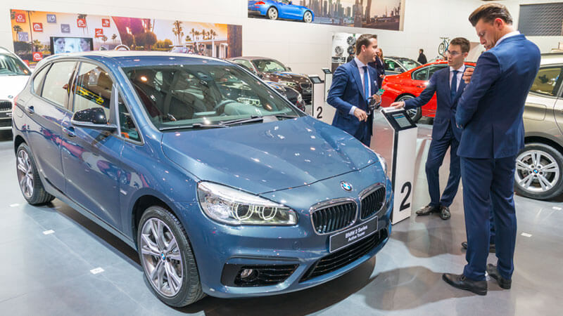 kopers en verkopers op het autosalon