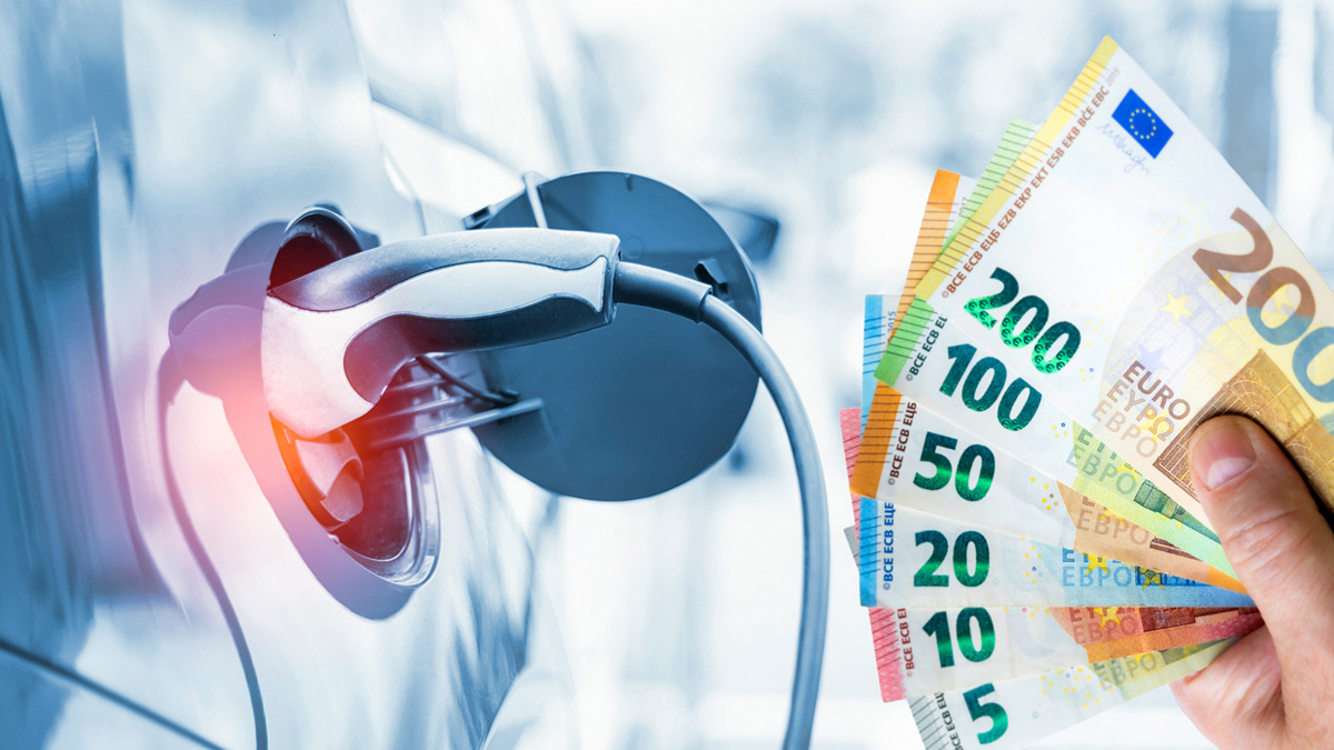 close-up van laadpoort in elektrische auto met hand ervoor die biljetten van 5 tot en met 200 euro vasthoudt