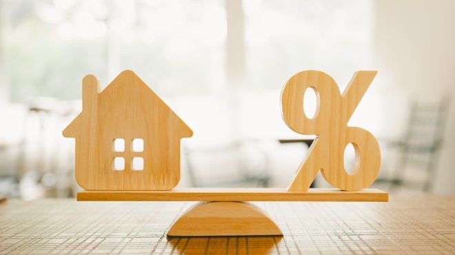 weegschaal met huis en % om de verhouding van je hypothecaire lening met rentevoet aan te duiden
