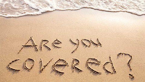 Tekst "are you covered?" geschreven in zand
